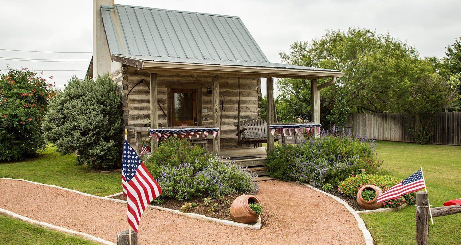 Bollinger Cabin, a historic log cabin with porch and American flag